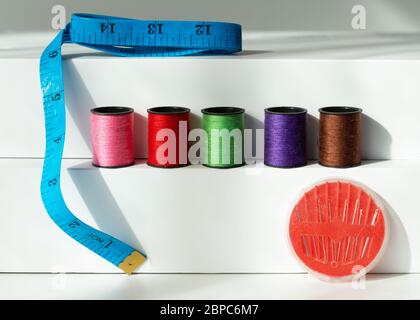 Kreative Komposition mit Spulen aus farbigen Fäden und Scheren. Nähzubehör, Schneidersatz. Stockfoto
