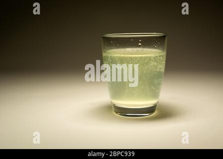 Die auflösende Tablette in Wasser in einem Glas, gerade Sicht Stockfoto