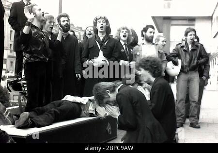 Archivbild der Gay-Aktivisten-Allianz-Gruppe, die in den späten 1970er Jahren vor einem W. Smith's Shop am Notting Hill Gate, London, England protestiert. W. Smith als Kette hatte beschlossen, den Verkauf der Zeitung "Gay News" einzustellen und damit die Proteste auszulösen. Die Gruppen der Gay Aktivisten Alliance in großbritannien protestierten in dieser Ära in vielen verschiedenen Geschäften von W. H. Smith. Der Sarg auf dem Boden in diesem Bild sollte den Tod der freien Rede und den Tod der ungehinderten Veröffentlichung symbolisieren. Stockfoto