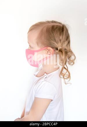 Mädchen in Gesichtsmaske. Kinderkleidung Gesichtsmask zum Schutz während Coronavirus und Grippe-Epidemie. Schutz vor Viren und Krankheiten.Sicherheit Atemschutzmasken. Stockfoto