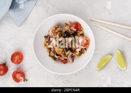 Reis mit Garnelen, Tintenfisch, frischen Tomaten und Zwiebeln. Asiatische Rezepte. Stockfoto