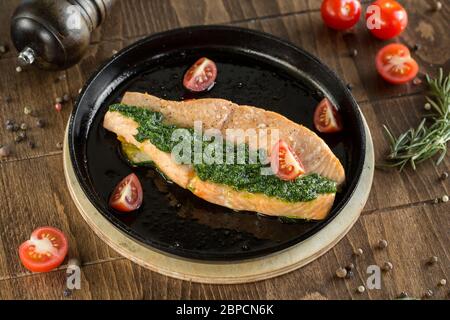 Gegrilltes Rotfischsteak. Serviert in einer Pfanne mit Kirschtomaten und Pesto. Stockfoto