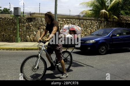 Valencia, Carabobo, Venezuela. Mai 2020. 18.Mai 2020. Ein Mann steht vor dem Benzinmangel, transportiert sich auf dem Fahrrad und nimmt seine kleine Tochter mit durch die verlassenen Straßen der Stadt Valencia, Bundesstaat Carabobo. Venezuela erwartet die Ankunft von Schifffahrtsbenzinschiffen aus dem Iran, bisher ist nicht bekannt, ob die Vereinigten Staaten Maßnahmen ergreifen, um die Ankunft von Kraftstoff an die Regierung Nicolas Maduro zu verhindern. Foto: Juan Carlos Hernandez Quelle: Juan Carlos Hernandez/ZUMA Wire/Alamy Live News Stockfoto