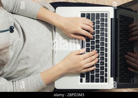 Mädchen arbeitet auf einem Laptop zu Hause auf der Couch mit ihrem Kätzchen. Freelance und Remote Quarantäne Konzept, Draufsicht. Stockfoto