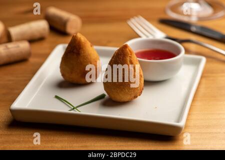 Coxinha mit gefüllten zerkleinerten Huhn, brasilianische traditionelle Lebensmittel. Stockfoto