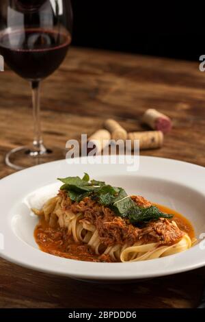 Pasta Bolognese Tagliatelle Nudeln mit rotem Boden zerkleinert Rindfleisch auf weißem Teller und verschwommenem Hintergrund. Stockfoto