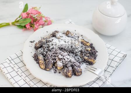 Kartoffelknödel mit Sulznocken mit gemahlener Mohnkerne und Zuckerpulver Stockfoto