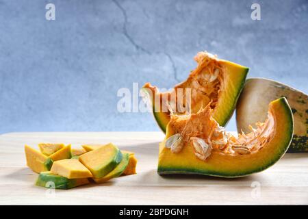 Kürbis Scheiben gewürfelt und Kürbis Brei auf einem Holz in dunklem Hintergrund. Konzept Kochen gehackten Kürbis. Lebensmittel Hintergrund. Selektiver Fokus. Stockfoto