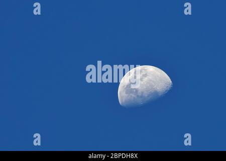 Mond über blauem Himmel Hintergrund / der Mond, wie er früh in seinem ersten Viertel oder spät in seinem letzten Viertel erscheint, wenn nur ein kleiner Bogen-förmigen Abschnitt von Stockfoto