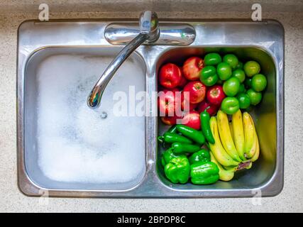 Gemüse und Obst auf einem Singen mit fließendem Wasser und Seife waschen Stockfoto