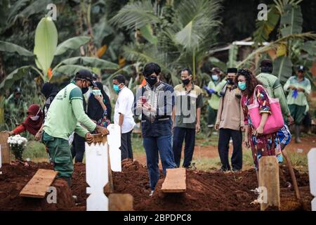 Ost-Jakarta, Indonesien. Mai 2020. Eine Familie fotografiert das Grab für ihre Verwandten unter den kürzlich gegrabenen Gräbern auf einem ausgewiesenen Friedhof für COVID-19 Coronavirus-Opfer auf dem Pondok Ranggon Friedhof in Jakarta. Die indonesische Regierung plant, die sozialen Beschränkungen (Lockdown) bei der Prävention von COVID-19 zu lockern, obwohl keine Daten einen Rückgang der Zahl der Opfer der Coronavirus-Pandemie zeigen. Indonesien hat bisher 18.010 Fälle von Coronavirus bestätigt, 1.191 Todesfälle und 4.324 Genesen. (Foto: Risa Krisadhi/Pacific Press) Quelle: Pacific Press Agency/Alamy Live News Stockfoto