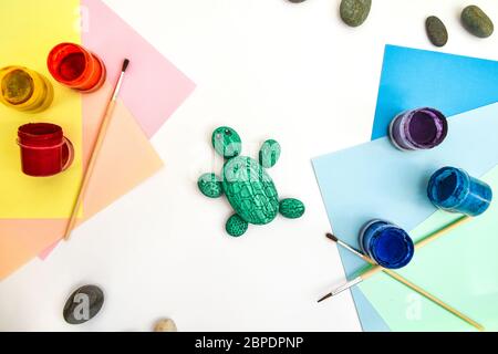 Schritt für Schritt eine Steinschildkröte auf einem Stein malen. Kinder Kunstprojekt. DIY-Konzept. Schritt für Schritt Fotoanleitung.Ansicht von oben. Arbeiten Sie mit Chi Stockfoto