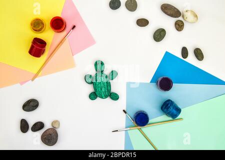 Schritt für Schritt eine Steinschildkröte auf einem Stein malen. Kinder Kunstprojekt. DIY-Konzept. Schritt für Schritt 5 Fotoanleitung.Ansicht von oben. Arbeiten mit c Stockfoto