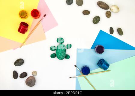 Schritt für Schritt eine Steinschildkröte auf einem Stein malen. Kinder Kunstprojekt. DIY-Konzept. Schritt für Schritt 3 Fotoanleitung.Ansicht von oben. Arbeiten mit c Stockfoto