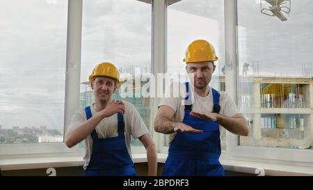 Baumeister lustigen Tanz in Helmen. Stockfoto