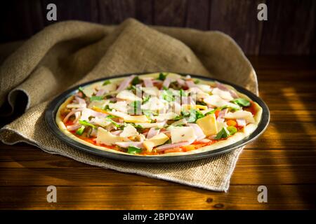 Rohe Pizza mit sortierter Füllung in Metallform Stockfoto