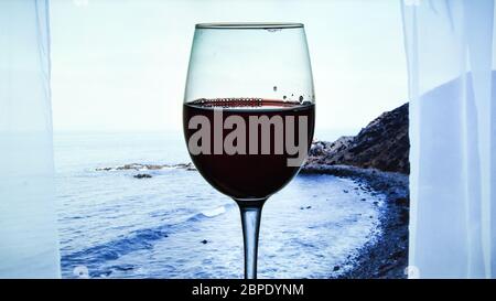 Glas Rotwein serviert im Freien auf tropischen Insel, Kanarische Inseln, Spanien mit wunderschönen blauen Ozean Blick aus dem Fenster, Urlaubszeit Stockfoto