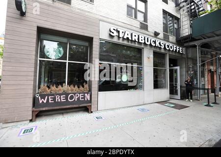 New York, USA. Mai 2020. Ein Mann wartet auf eine Bestellung vor einem Starbucks Café, das nur zum Mitnehmen erhältlich ist, in New York, USA, am 18. Mai 2020. Die Anzahl der COVID-19-Fälle in den Vereinigten Staaten überstieg 1.5 Millionen am Montag, erreichte 1,500,753 von 16:03 Uhr (2003 GMT), nach dem Center for Systems Science and Engineering (CSSE) an der Johns Hopkins University. Die nationale Todesrate von COVID-19 stieg laut CSSE auf 90,312. Kredit: Wang Ying/Xinhua/Alamy Live News Stockfoto