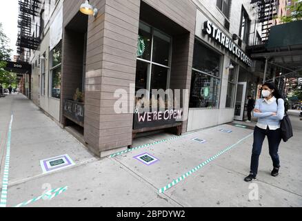 New York, USA. Mai 2020. Eine Frau geht an einem Starbucks Café vorbei, das nur zum Mitnehmen erhältlich ist, und zwar in New York, USA, am 18. Mai 2020. Die Anzahl der COVID-19-Fälle in den Vereinigten Staaten überstieg 1.5 Millionen am Montag, erreichte 1,500,753 von 16:03 Uhr (2003 GMT), nach dem Center for Systems Science and Engineering (CSSE) an der Johns Hopkins University. Die nationale Todesrate von COVID-19 stieg laut CSSE auf 90,312. Kredit: Wang Ying/Xinhua/Alamy Live News Stockfoto