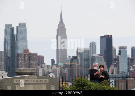 New York, USA. Mai 2020. Menschen, die Gesichtsmasken tragen, fotografieren die Skyline von Manhattan aus Weehawken in New Jersey, USA, am 18. Mai 2020. Die Anzahl der COVID-19-Fälle in den Vereinigten Staaten überstieg 1.5 Millionen am Montag, erreichte 1,500,753 von 16:03 Uhr (2003 GMT), nach dem Center for Systems Science and Engineering (CSSE) an der Johns Hopkins University. Die nationale Todesrate von COVID-19 stieg laut CSSE auf 90,312. Kredit: Wang Ying/Xinhua/Alamy Live News Stockfoto