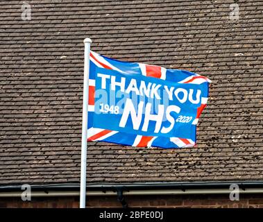 'Danke NHS' Gewerkschaftsflagge fliegt auf Flaggenmast vor dem Haus, um dem NHS während der Coronavirus-Pandemie zu danken, Mai 2020, England, Großbritannien Stockfoto