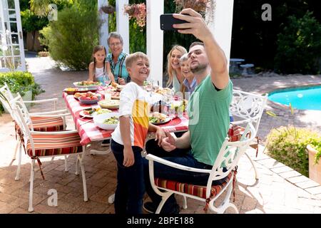 Kaukasische Familie der drei Generationen, die ein Selfie im Garten machen Stockfoto