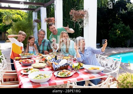 Kaukasische Familie der drei Generationen, die ein Selfie im Garten machen Stockfoto