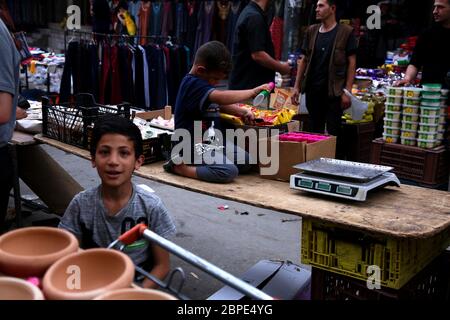 16. Mai 2020: Gaza, Palästina. 16 Mai 2020. Viele Palästinenser besuchen und kaufen während des Ramadan auf offenen Märkten ein, trotz der Bedrohung durch Covid-19. Märkte sind normalerweise sehr überfüllt am Ramadan, und sie haben eine besondere Atmosphäre während des heiligen Monats. Doch die Anwesenheit einer großen Zahl von Kindern, die Süßigkeiten an Ständen verkaufen und machen, unterstreicht die schwierige wirtschaftliche Realität des Gazastreifens. Die lange Blockade des Gazastreifens hat die Arbeitslosenquote und die Armut stark erhöht und zwingt Kinder oft, zur Unterstützung ihrer Familie zu arbeiten und die Schulbildung aufzugeben (Bild: © Samar Abu Elouf/IMAG Stockfoto