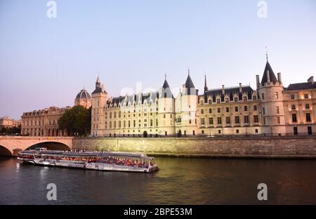 Touristenschiff auf der seine und Conciergerie-Gebäude im Hintergrund in Paris, Frankreich. Stockfoto