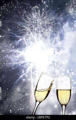 Gläser mit Champagner gegen Feuerwerk und Weihnachtslichter Stockfoto