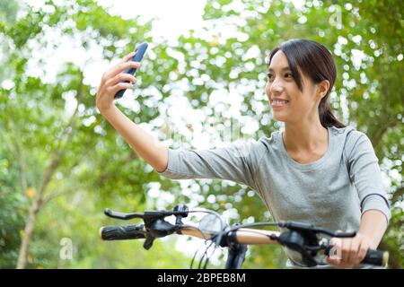 Asiatische junge Frau wie Radfahren und unter selfie Stockfoto
