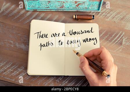 Retro-Effekt und getöntes Bild einer Frau, die auf einem Notizbuch handschreibt. Handgeschriebenes Zitat Es gibt tausend Wege zu jedem Unrecht als inspirierende Conce Stockfoto