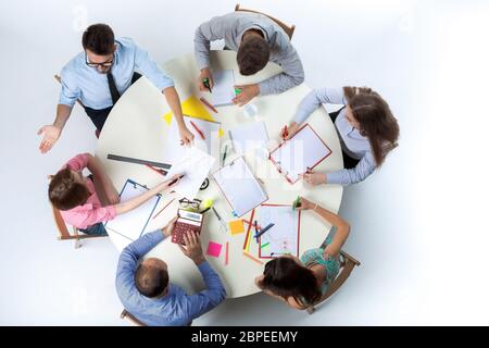 Draufsicht des Business-Teams, sitzen an einem runden Tisch auf weißem Hintergrund. Konzept der erfolgreichen Teamarbeit Stockfoto