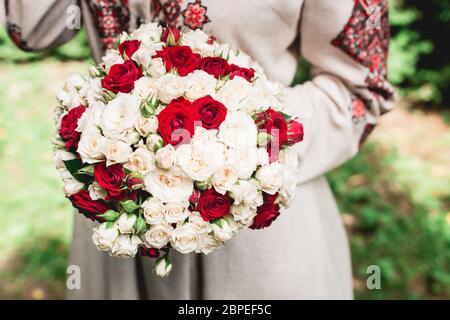 Braut halten in der Hand Brautstrauß von biege und roten Rosen. Stockfoto