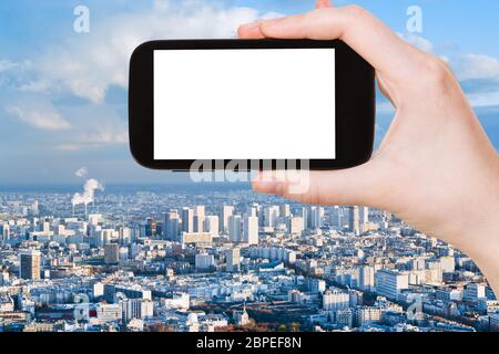 Konzept - Hand hält, das Smartphone mit Bildschirm und Paris Skyline im Hintergrund ausschneiden zu reisen Stockfoto