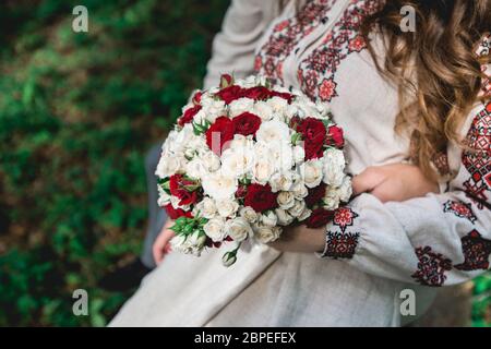 Braut halten in der Hand Brautstrauß von biege und roten Rosen. Stockfoto