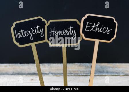 Geschäftliche Integrität, Ehrlichkeit, Ethik mit Kreide auf Holz mini Blackboard Labels geschrieben, defokussierten Schiefertafel und Holz Tisch im Hintergrund Stockfoto