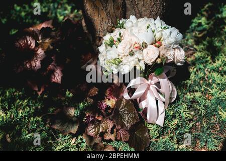 Luxuriöser Brautstrauß aus weißen Pfingstrosen und Rosen in Nadelbüschen Stockfoto