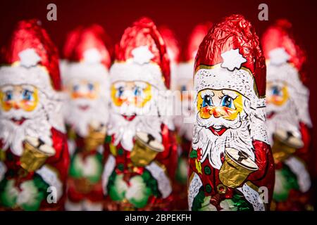 Nahaufnahme des Weihnachtsmanns Schokolade Figur auf rotem Grund Stockfoto