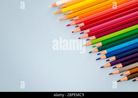 Eine Auswahl von Buntstiften, die diagonal wie ein Regenbogen von dunkel bis hell aufgereiht sind Stockfoto