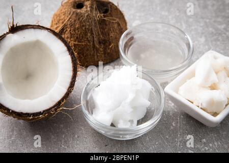 Kokosnuss mit Kokosöl in Glas auf Holz- Hintergrund. Stockfoto