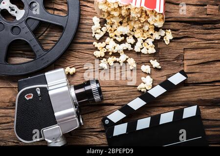 Nahaufnahme der Film Kamera mit filmrolle Klappe und Popcorn auf Holz Stockfoto