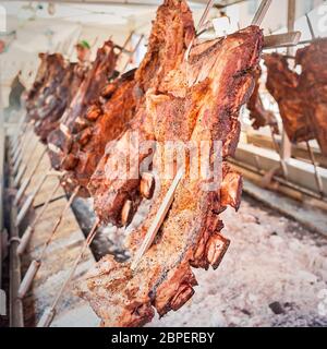 Gebratenes Fleisch Rindfleisch gekocht auf einem vertikalen Grills um Feuer gelegt. Asado, traditionellen Barbecue-Gericht in Argentinien Stockfoto