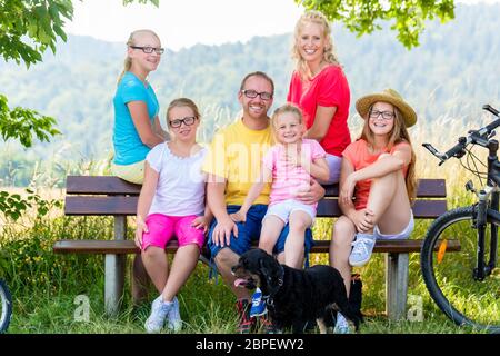 Familie auf Tour mit Fahrrädern in Ruhe auf der Werkbank, Mutter, Vater und Kinder ruhen Stockfoto