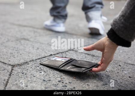 Kommissionierung in der Nähe einer Person, eine verlorene Brieftasche Auf der Straße Stockfoto