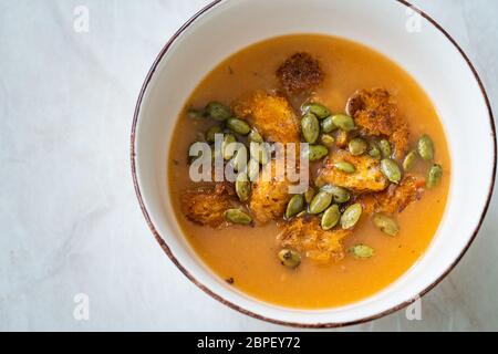 Hausgemachte Butternusskürbis-Suppe mit Kürbissoße, Kürbiskernen, Karotten und knusprigen Croutons. Bio Gesunde Lebensmittel. Stockfoto