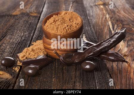 Bio Johannisbrot Bean, Pod und carob Pulver auf weißem Hintergrund. Gesunde Kakao Alternative. Stockfoto