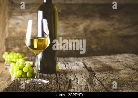 Wein. Glas Weißwein im Weinkeller. Alte Weißwein auf Holz. Stockfoto
