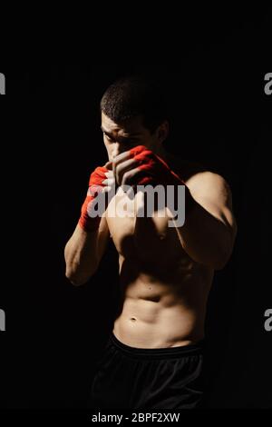 Sportboxer stanzen mit Entschlossenheit und Vorsorge über schwarzem Hintergrund. Konzept für Stärke, Angriff und Bewegung. kaukasisches Modell in Bewegung bringen Stockfoto