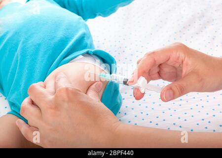 Kinderarzt geben einen Jungen intramuskuläre Injektion. Medizin Konzept. Stockfoto